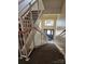 Carpeted stairwell with white railing leading down to an exit door and window at the building's ground floor at 17119 Doe Valley Ct, Cornelius, NC 28031