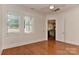 Bright bedroom featuring hardwood floors, a ceiling fan, and doorway to the kitchen at 17210 Sulky Plough Rd # 1206, Charlotte, NC 28277