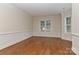 Inviting living room featuring hardwood floors, classic wainscoting, and large windows at 17210 Sulky Plough Rd # 1206, Charlotte, NC 28277
