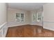 Bright living room featuring hardwood floors, classic wainscoting, and large windows at 17210 Sulky Plough Rd # 1206, Charlotte, NC 28277