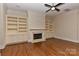 Living room with hardwood floors, built-in bookshelves, fireplace, and a ceiling fan at 17210 Sulky Plough Rd # 1206, Charlotte, NC 28277