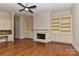 Living room with hardwood floors, built-in bookshelves, fireplace, and a ceiling fan at 17210 Sulky Plough Rd # 1206, Charlotte, NC 28277