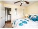 Cozy bedroom with a decorative ceiling fan, light yellow walls, and a plush bed with bright blue accents at 1957 8Th Street Se Ln, Hickory, NC 28602