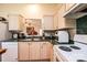 Kitchen features wooden cabinets, tile backsplash, stainless steel sink, and white appliances at 1957 8Th Street Se Ln, Hickory, NC 28602