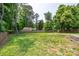 Spacious backyard features lush lawn, mature trees, and a wooden fence at 2005 Schofield Pl, Salisbury, NC 28144