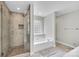 Bright bathroom with glass shower, tub under a glass block window, and neutral colored tile at 2005 Schofield Pl, Salisbury, NC 28144