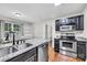 Well-lit kitchen features stainless appliances, granite counters, undermount sink, and a view of an adjacent dining area at 2005 Schofield Pl, Salisbury, NC 28144