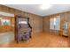 Charming living room featuring hardwood floors, wood paneling, and vintage organ at 208 Lipe Rd, Troutman, NC 28166