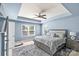 Comfortable bedroom featuring a tray ceiling, king size bed, a ceiling fan, and large windows at 2213 Iron Works Dr, Clover, SC 29710