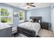 Bedroom with neutral walls featuring a queen bed, ceiling fan, and two windows at 2213 Iron Works Dr, Clover, SC 29710