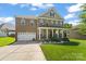 Charming brick home with a welcoming front porch, lush lawn, and two-car garage at 2213 Iron Works Dr, Clover, SC 29710
