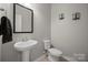 Simple half-bath features a pedestal sink, modern fixtures, and neutral walls at 240 Bells Crossing Dr, Mooresville, NC 28117