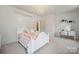Bright bedroom featuring a white bed frame, chandelier, and vanity table with mirror at 240 Bells Crossing Dr, Mooresville, NC 28117