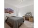 This bedroom features a bed, desk, a large artwork, and a window at 240 Bells Crossing Dr, Mooresville, NC 28117