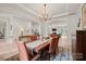 Bright dining room with decorative rug, open archway to living room, and modern lighting fixture at 240 Bells Crossing Dr, Mooresville, NC 28117