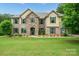 Stunning two-story brick home with a beautiful stone archway and manicured lawn at 240 Bells Crossing Dr, Mooresville, NC 28117