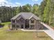 This two-story home is crafted with brick and stone and surrounded by lush greenery and a mature treeline at 240 Bells Crossing Dr, Mooresville, NC 28117