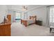 Bright main bedroom boasts a tray ceiling, neutral carpet, and large windows at 240 Bells Crossing Dr, Mooresville, NC 28117