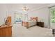Spacious bedroom with tray ceiling, ceiling fan, large windows, and wood furniture at 240 Bells Crossing Dr, Mooresville, NC 28117