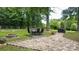 Outdoor dining area featuring a stone patio with a table, chairs, fire pit, and grill, surrounded by greenery at 2618 Pineview Dr, Lancaster, SC 29720