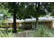 Back exterior of a brick home showing a yard with mature trees and a gravel area with shrubs at 2618 Pineview Dr, Lancaster, SC 29720