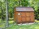 Exterior view of a wooden storage shed with a brown metal roof; lattice and rocks accent the base at 2618 Pineview Dr, Lancaster, SC 29720