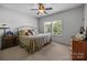 Bedroom featuring a queen bed, wood furniture, neutral walls, and a bright window at 3009 Botetourt Ct, Matthews, NC 28104