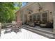 This covered back deck boasts outdoor seating, ceiling fans, and offers a beautiful view of the property's wooded surroundings at 3009 Botetourt Ct, Matthews, NC 28104
