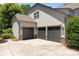 Spacious three-car garage with gray doors, stone accents, exterior lights, and a large concrete driveway at 3009 Botetourt Ct, Matthews, NC 28104