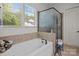 Bright bathroom featuring a soaking tub, a separate shower, and large window at 3009 Botetourt Ct, Weddington, NC 28104