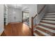 Elegant foyer featuring hardwood floors, a chandelier, staircase, and an arched entryway to a dining area at 3009 Botetourt Ct, Weddington, NC 28104