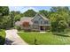Charming two-story home with lush landscaping, a well-maintained lawn, and a curved driveway at 3009 Botetourt Ct, Weddington, NC 28104