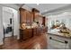 Spacious kitchen with dark wood cabinetry, granite countertops, and a view into the adjacent dining area at 3009 Botetourt Ct, Weddington, NC 28104