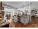 Open kitchen layout showcasing a large island, granite countertops, stainless steel appliances, and hardwood flooring at 3009 Botetourt Ct, Weddington, NC 28104