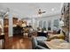 Open-concept living room with a stone fireplace, hardwood floors, and a seamless flow to the kitchen at 3009 Botetourt Ct, Weddington, NC 28104