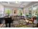 Cozy living room featuring a piano, coffered ceiling, large windows, and comfortable seating area at 3009 Botetourt Ct, Weddington, NC 28104