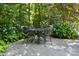Outdoor dining set on stone patio, surrounded by beautiful blue hydrangea bushes and lush greenery at 3009 Botetourt Ct, Weddington, NC 28104