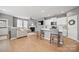 Bright, open-concept living room featuring wood floors, a fireplace, and access to the kitchen at 3013 Coventry Commons Dr, Mint Hill, NC 28227