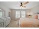 A well-lit main bedroom with neutral walls, carpet flooring, ceiling fan, and a decorative dresser with mirror at 3013 Coventry Commons Dr, Mint Hill, NC 28227