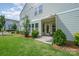 Back patio area with small awning and view of small yard and lush green landscaping at 355 Ladybird Ln, Pineville, NC 28134