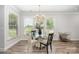 Sunlit dining area featuring a modern chandelier, seating for four, and view of the backyard at 355 Ladybird Ln, Pineville, NC 28134
