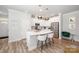 Charming eat-in kitchen features an island with barstool seating, stainless appliances, and modern pendant lighting at 355 Ladybird Ln, Pineville, NC 28134
