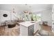 Modern kitchen with island flows seamlessly into the living area, bathed in natural light, perfect for entertaining at 355 Ladybird Ln, Pineville, NC 28134