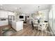Bright, open-concept living space with eat-in kitchen, stainless steel appliances, dining space, and staircase at 355 Ladybird Ln, Pineville, NC 28134