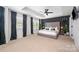 Spacious main bedroom with a decorative bed frame, a dark accent wall, tray ceiling, and soft lighting at 355 Ladybird Ln, Pineville, NC 28134