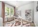 Stylish home office featuring a white desk, modern shelves, and a comfortable seating area by the bright window at 355 Ladybird Ln, Pineville, NC 28134