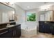 Symmetrical bathroom featuring a large soaking tub, double vanity and natural light at 3808 Halcyon Dr, Huntersville, NC 28078