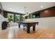 Spacious game room features a pool table, stylish lighting, and large windows at 3808 Halcyon Dr, Huntersville, NC 28078