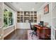 Well-lit home office with built-in bookshelves, a large window, and a hardwood desk at 3808 Halcyon Dr, Huntersville, NC 28078