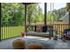 Covered porch with inviting swing and outdoor seating that overlook the lush backyard at 4143 Willow Haven Dr, Denver, NC 28037